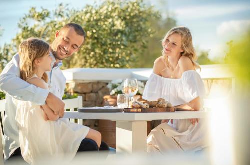 a man and woman sitting at a table at Sani Club in Sani Beach