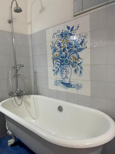 a white tub in a bathroom with a blue and white vase at Ivana B&B in Catania