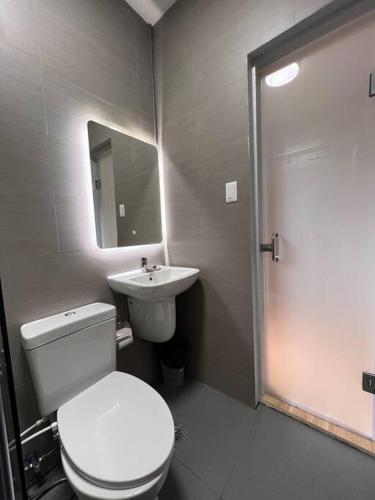 a bathroom with a white toilet and a sink at Serene Holiday Home Mt Taal View lel in Lemery