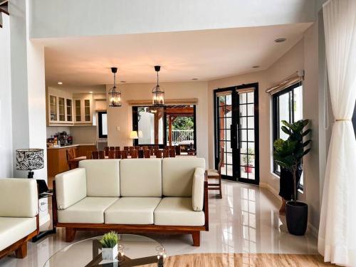 a living room with a white couch and a kitchen at Serene Holiday Home Mt Taal View lel in Lemery