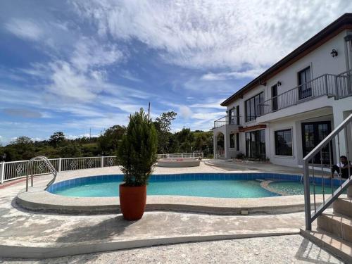 a house with a swimming pool and a potted plant at Serene Holiday Home Mt Taal View lel in Lemery