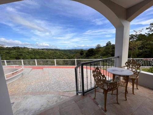 a patio with a table and chairs on a balcony at Serene Holiday Home Mt Taal View lel in Lemery