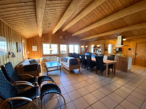 a living room with a table and chairs and a kitchen at Hafjell Grenda lejligheder og hytter in Hafjell