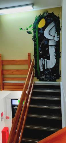 a staircase with a painting on the wall at Silverfern Backpackers in Auckland