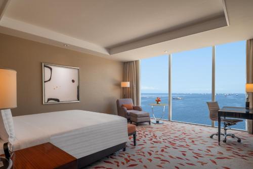 a hotel room with a bed and a large window at Solaire Resort Entertainment City in Manila