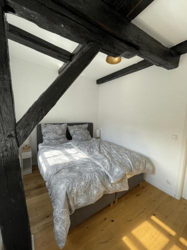 a bedroom with a bed in a room with beams at BacksteinFlair - LüneMitte in Lüneburg