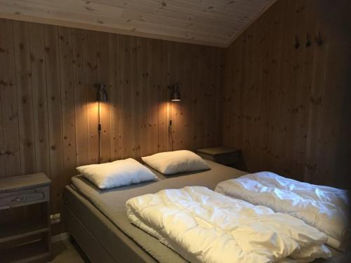 a bedroom with two beds with white blankets and pillows at Hafjell Grenda lejligheder og hytter in Hafjell