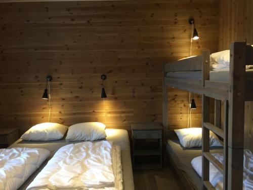 two bunk beds in a room with a wooden wall at Hafjell Grenda lejligheder og hytter in Hafjell