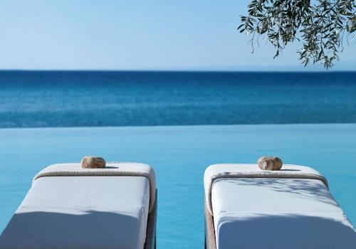 a pair of white chairs in front of the ocean at Sani Beach in Sani Beach