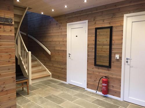 a room with a wooden wall with a staircase and a fire hydrant at Hafjell Grenda lejligheder og hytter in Hafjell