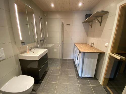 a bathroom with a toilet and a sink and a shower at Hafjell Grenda lejligheder og hytter in Hafjell