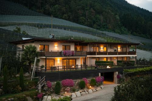 a building with flowers in front of it at Landhaus Freiburgerhof in Rifiano