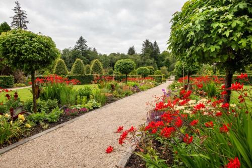 a garden with colorful flowers and a path at Ballynahinch Castle Hotel in Ballynahinch