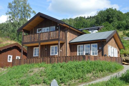 a large wooden house on top of a hill at Hafjell Grenda lejligheder og hytter in Hafjell
