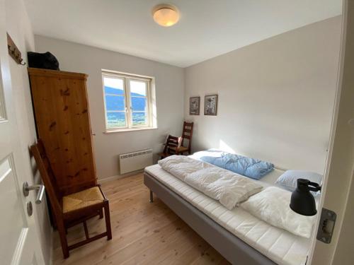a bedroom with a bed and a chair and a window at Hafjell Grenda lejligheder og hytter in Hafjell