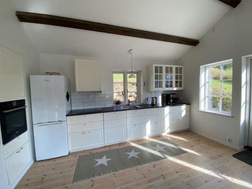 a kitchen with white appliances and a wooden floor at Hafjell Grenda lejligheder og hytter in Hafjell