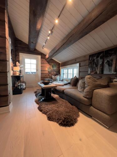 a living room with a couch and a table at Hafjell Grenda lejligheder og hytter in Hafjell