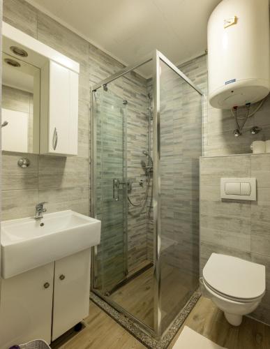 a bathroom with a shower and a toilet and a sink at Apartments Tanja & Josipa in Pag
