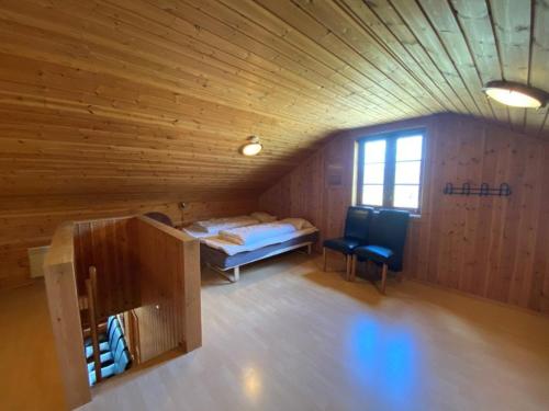 a room with a bed and a chair in a room at Hafjell Grenda lejligheder og hytter in Hafjell