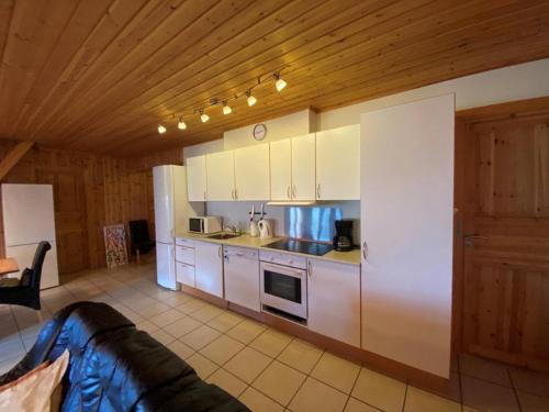 a kitchen with white cabinets and a wooden ceiling at Hafjell Grenda lejligheder og hytter in Hafjell