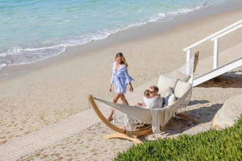 a woman and a man in a hammock on the beach at Sani Beach in Sani Beach