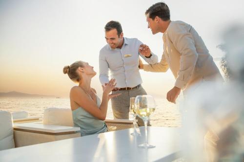 a group of people standing around a table on the beach at Sani Beach in Sani Beach