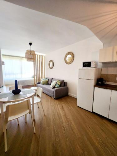 a kitchen and living room with a couch and a table at Estudio MELMAR en Playamar in Torremolinos