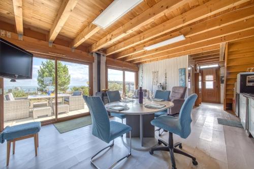une salle à manger avec une table, des chaises et une télévision dans l'établissement Chalet Les Pieds Dans L'eau, au Le Verdon-sur-Mer