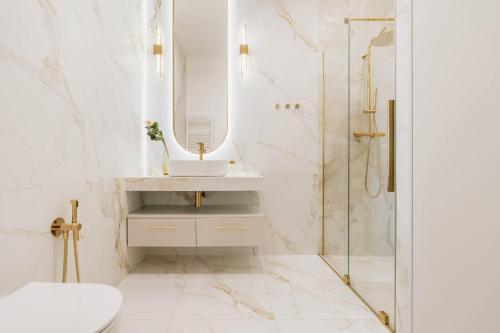 a bathroom with a sink and a shower with a mirror at Sol Marina Resort Wyspa Sobieszewska II - LoftAffair Collection in Wiślinka