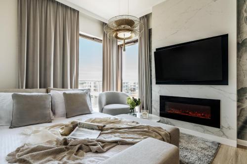 a living room with a bed and a fireplace at Sol Marina Resort Wyspa Sobieszewska II - LoftAffair Collection in Wiślinka