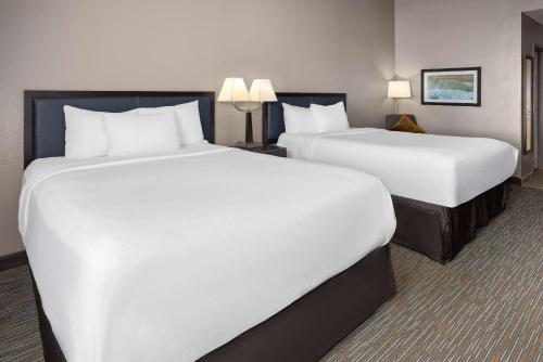 two beds in a hotel room with white sheets at La Quinta Inn & Suites by Wyndham Mooresville in Mooresville