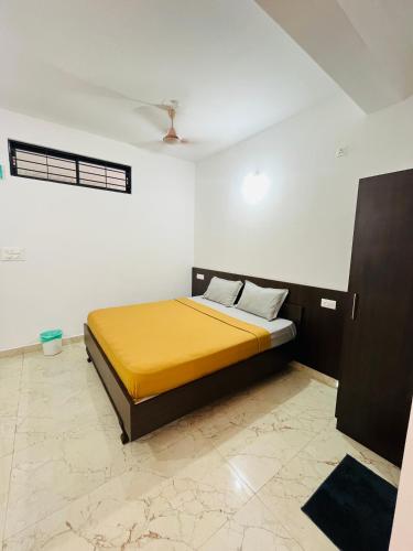 a bedroom with a yellow bed in a room at Nagashree stay inn chickamagalur in Chikmagalūr