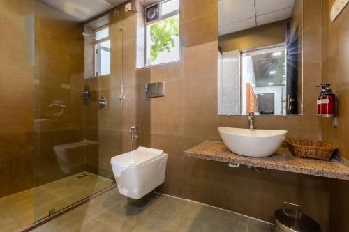 a bathroom with a toilet and a sink and a shower at Coco Bliss By Mauli Stays in Manor