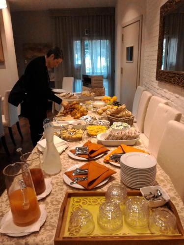 Un homme debout sur une longue table avec de la nourriture dans l'établissement Hotel Le Vigne di Corvino, à Casteggio