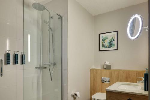 a bathroom with a glass shower and a sink at DoubleTree by Hilton London Chelsea in London