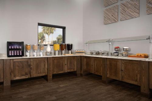 a kitchen with wooden cabinets and a counter with food at DoubleTree by Hilton St. Augustine Historic District in Saint Augustine