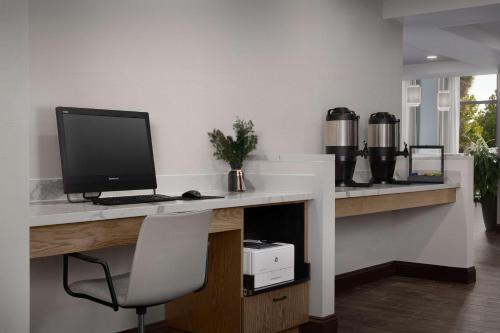 a desk with a computer monitor and a chair at DoubleTree by Hilton St. Augustine Historic District in Saint Augustine