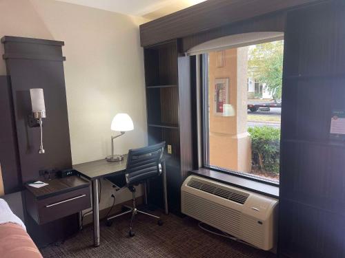 a hotel room with a desk and a window at Quality Inn Dalton Central in Dalton