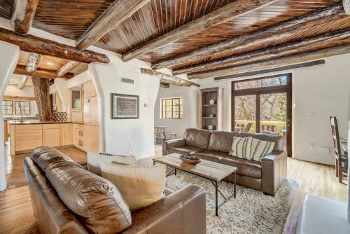 a living room with a leather couch and a table at Adobe del Sol - House & Cottage by The Broadmoor in Colorado Springs