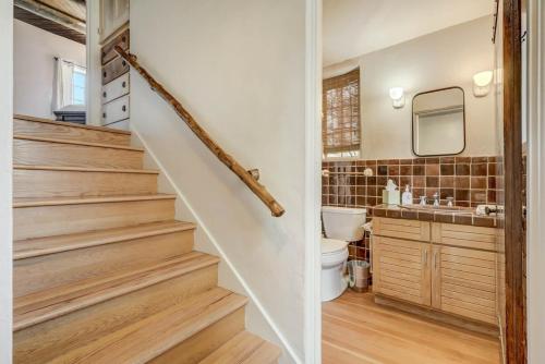 a bathroom with a staircase with a toilet and a sink at Adobe del Sol - House & Cottage by The Broadmoor in Colorado Springs