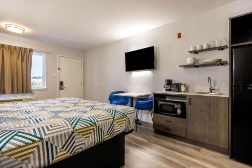 a hotel room with a bed and a kitchen at Studio 6 Fort Worth, TX - Stockyards East in Fort Worth