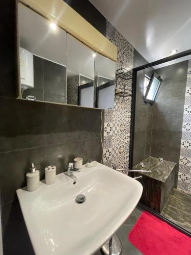 a bathroom with a white sink and a mirror at Studio Rooftop in Tangier