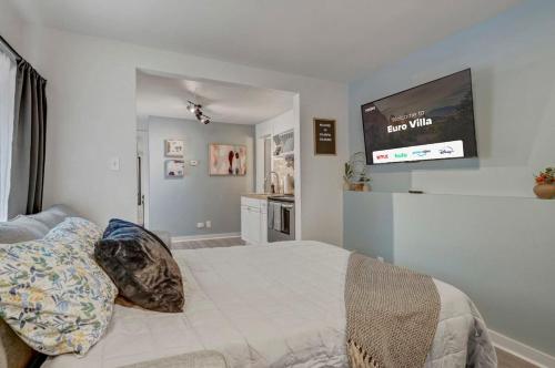 a bedroom with a bed with a tv on the wall at Euro Villa - Walkable Location Scenic Views in Colorado Springs