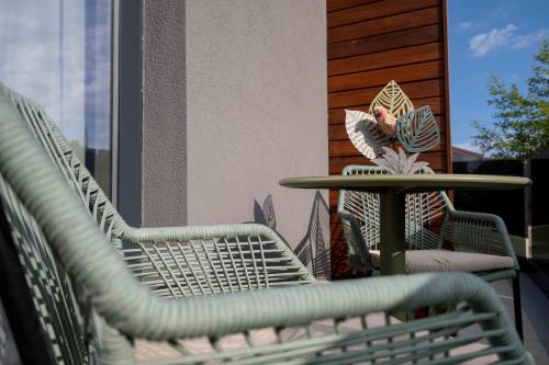 two wicker chairs and a table on a patio at Divina Charme in Mascalucia