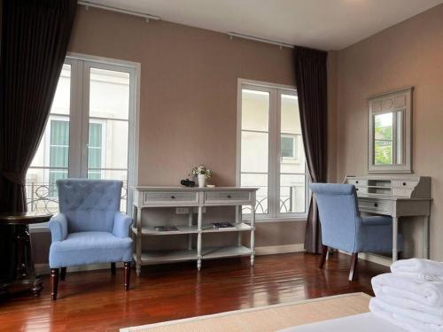 a room with two chairs and a desk and windows at 3BR Sukhumvit Townhouse, close to Emsphere and BTS MRT in Bangkok
