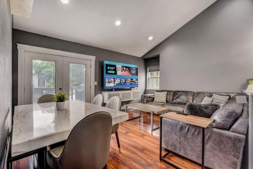 a living room with a table and a couch at Redwood Haus Premier Spot Hot Tub BBQ in Colorado Springs