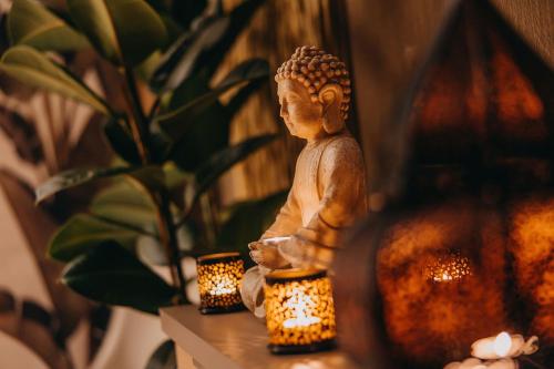 a statue sitting on a table next to two candles at Hotel Linea Mare in Pobierowo