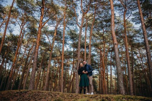 a man and woman standing in front of a forest at Hotel Linea Mare in Pobierowo