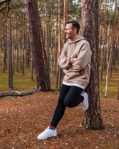a man standing next to a tree in the woods at Hotel Linea Mare in Pobierowo