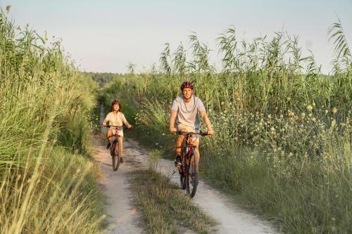 two people riding bikes down a dirt road at Sani Beach in Sani Beach